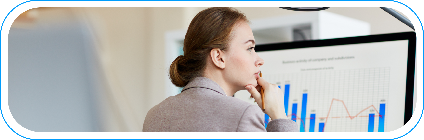 Kobieta analizująca wykresy i dane na ekranie komputera – analityka predykcyjna i optymalizacja kosztów operacyjnych w firmie.